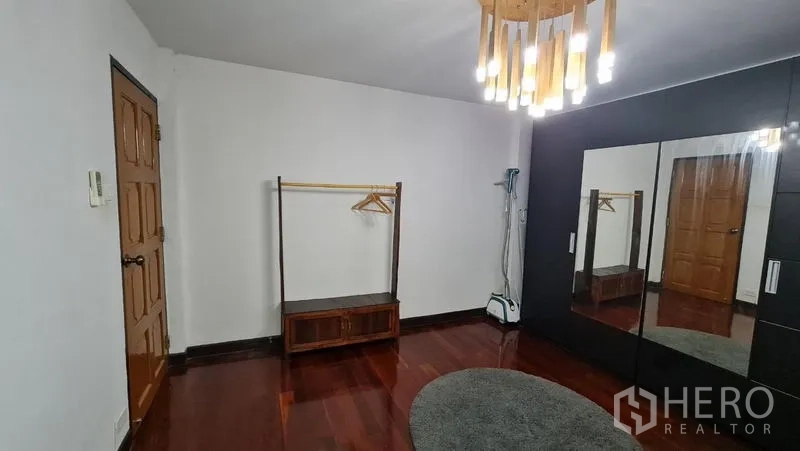 Detached House for rent in Saphan Sung, Bangkok - Dressing room with mirrored wardrobe and polished wood floors.