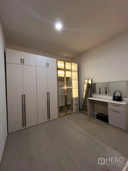 Townhouse for rent - Dressing room featuring built-in wardrobes, glass-door closet and vanity desk.