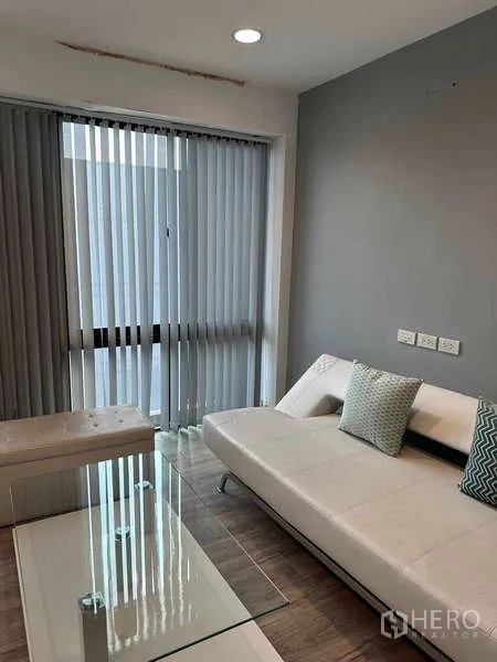 带办公室的家 出租在Bueng Kum, Bangkok - 舒适休闲区，白色沙发、玻璃茶几与推拉百叶。