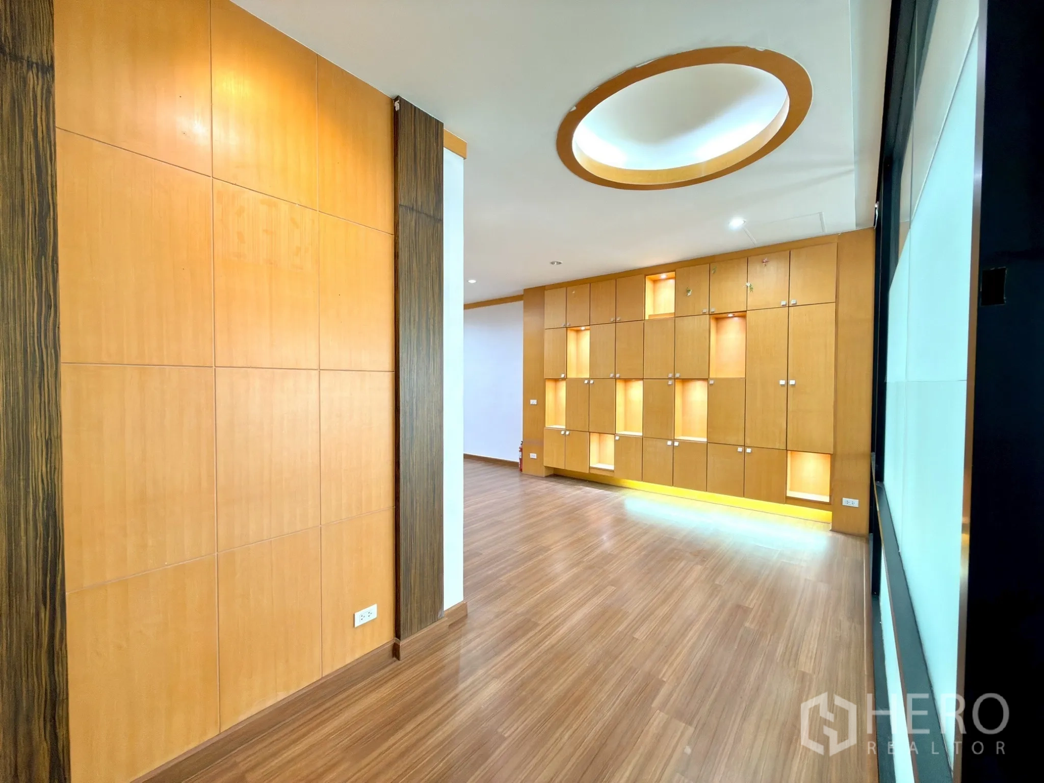 ออฟฟิศ for rent in Watthana, Bangkok - โถงทางเข้าพร้อมดีไซน์เพดานวงกลมและตู้โชว์ไฟในตัวตลอดแนวผนัง.