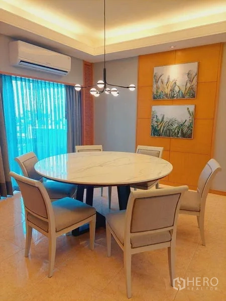 Apartment for rent - Dining area with a round marble-top table for six, pendant light, air conditioner and sheer curtains.