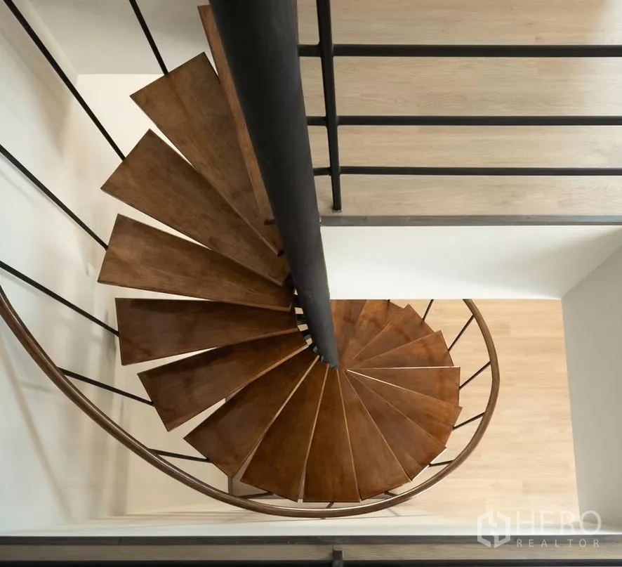 Home Office for sale in Bang Kapi, Bangkok - Overhead view of a wooden spiral staircase with metal balustrade.