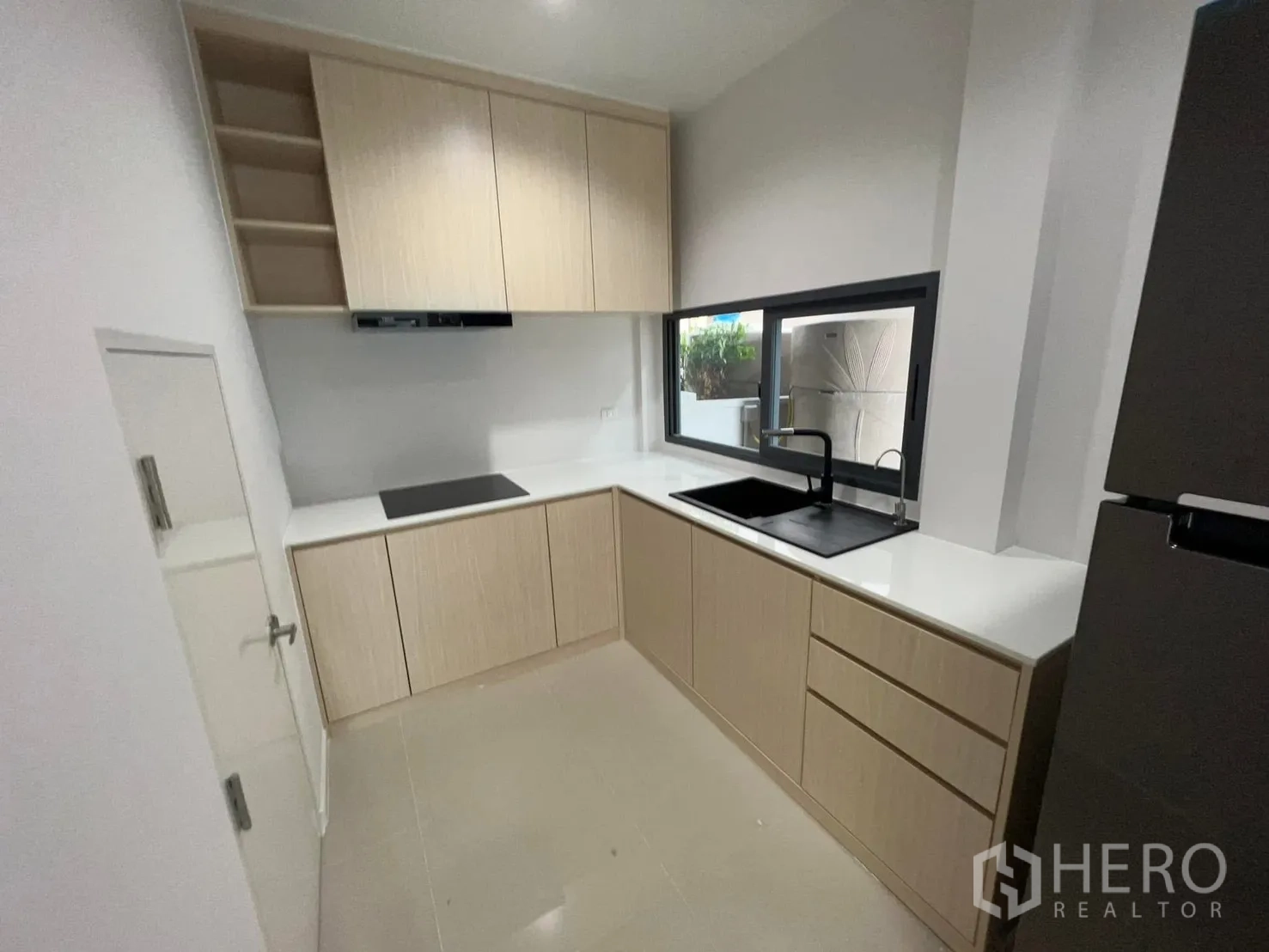 บ้านแฝด for rent in Saphan Sung, Bangkok - มุมครัวอีกด้านแสดงเคาน์เตอร์รูปตัวแอล อ่างล้างจานและหน้าต่าง