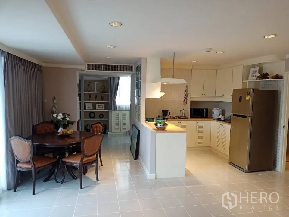 คอนโด for rent in Watthana, Bangkok - ครัวเปิดตู้สีขาวพร้อมโต๊ะทานอาหารและตู้เย็นขนาดใหญ่