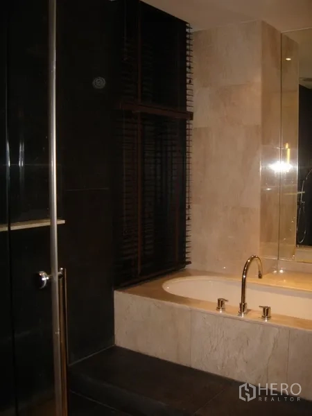 Condominium for rent in Sathon, Bangkok - Luxurious bathroom with soaking tub and separate shower with dark tile.