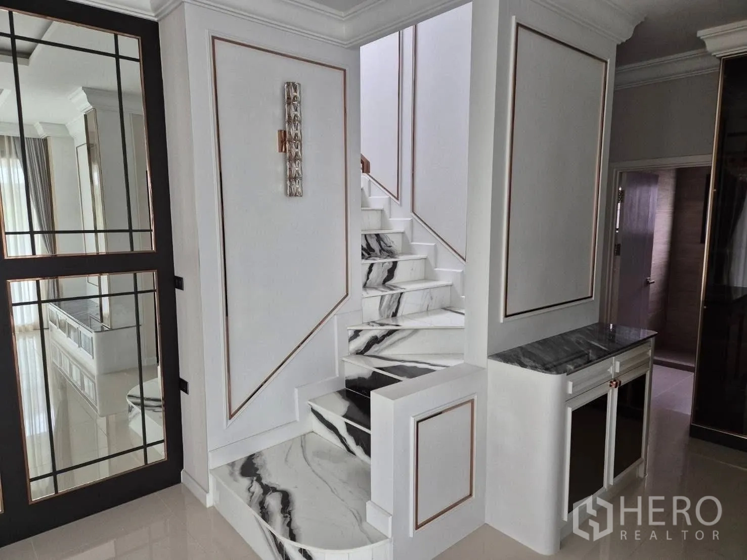 Detached House for sale in Bang Kruai, Nonthaburi - Entry area showing mirrored glass doors and marble stairs with accent cabinet.