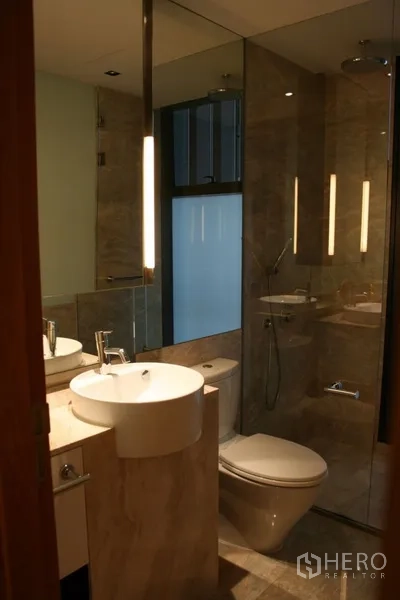 Condominium for rent in Sathon, Bangkok - Contemporary bathroom with glass-enclosed shower, vessel basin, and backlit mirror.