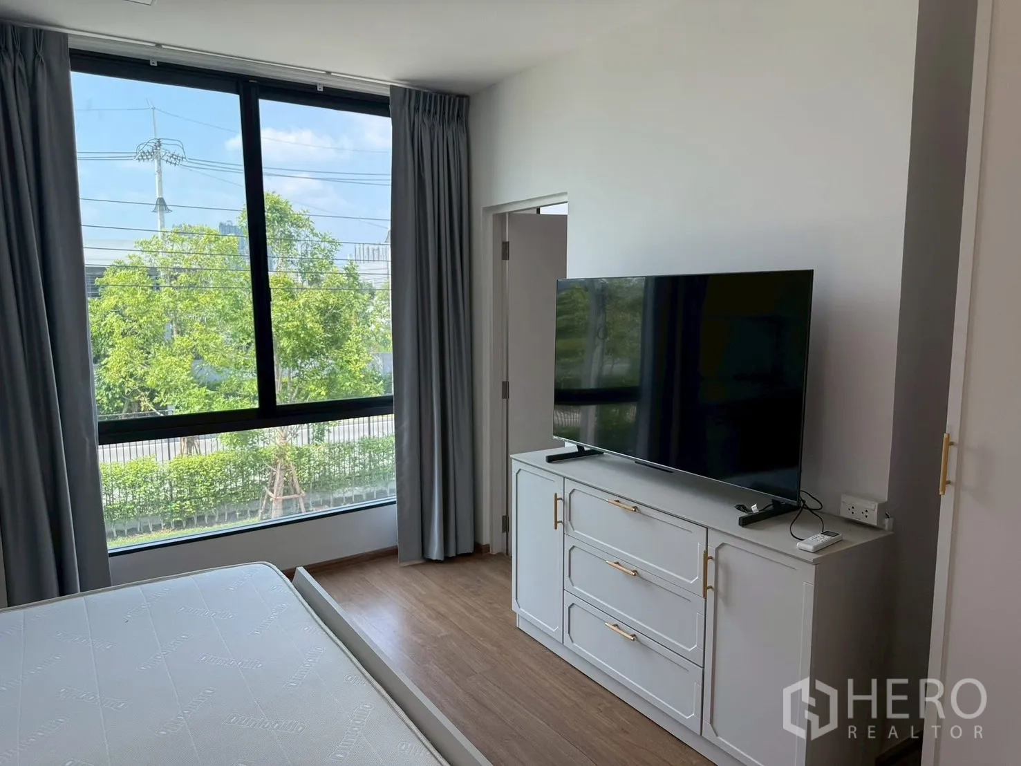 联排别墅 for rent in Bang Phli, Samut Prakan - 主卧配大窗、电视与柜子及窗帘。