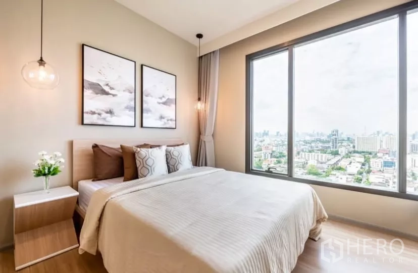 Condominium for rent in Chatuchak, Bangkok - Master bedroom with queen bed, large window and panoramic city skyline view.
