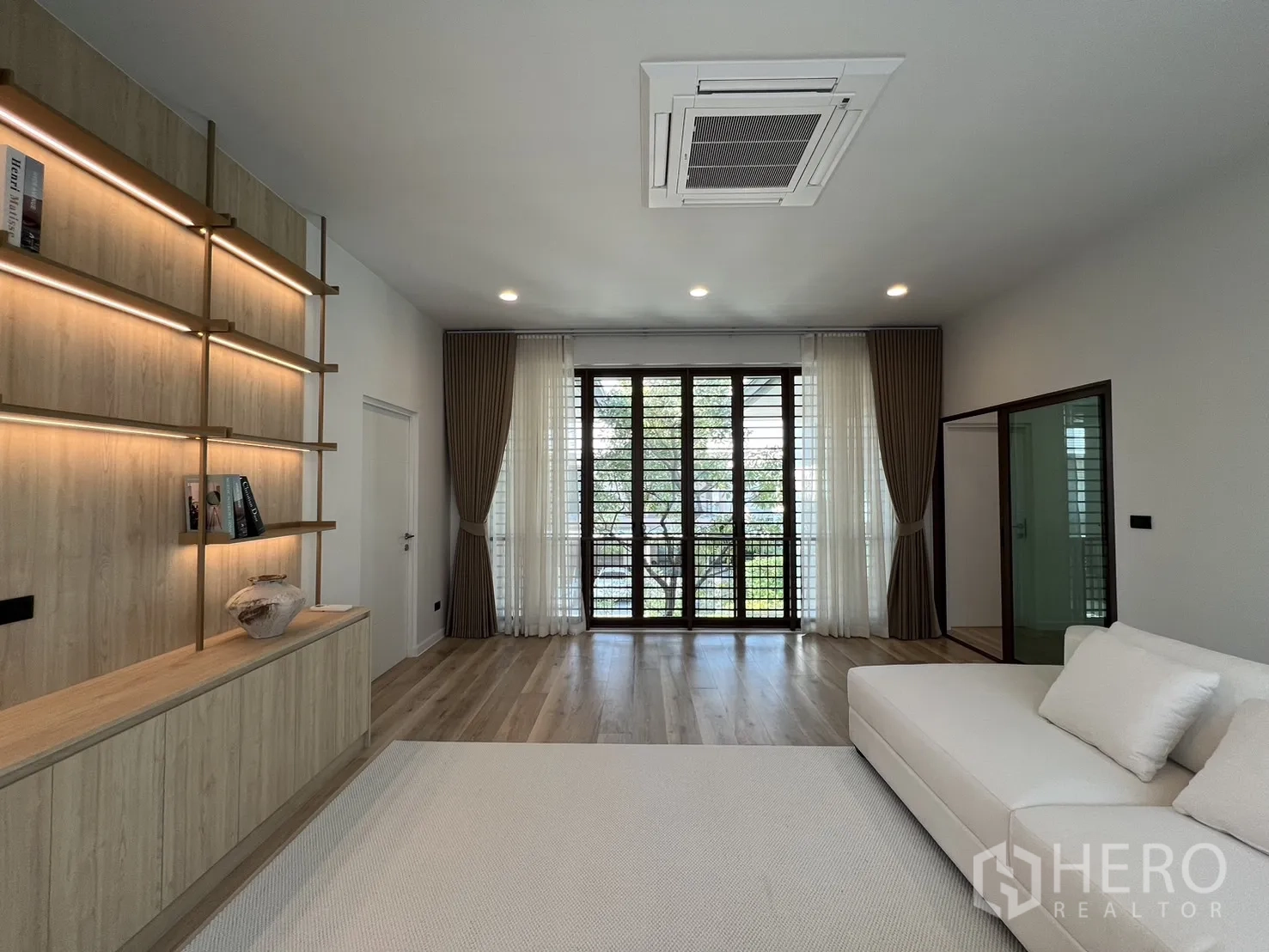 独立式住宅 出租或出售在Bang Kapi, Bangkok - 二层起居区，大沙发、木地板与氛围灯。