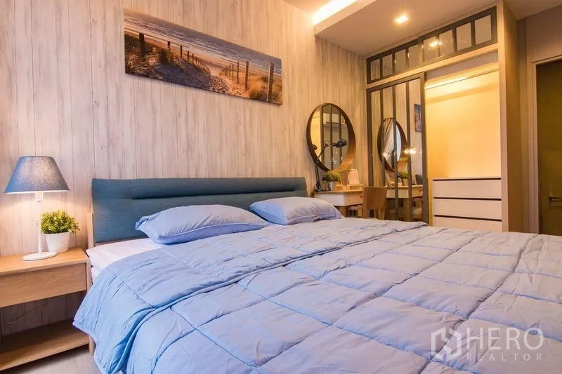 Condominium for sale in Watthana, Bangkok - Bedroom featuring upholstered headboard, mirrored wardrobe and a vanity desk.