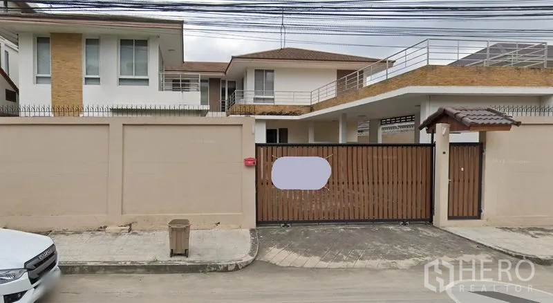 Detached House for rent in Prawet, Bangkok - Two-storey detached house in Prawet, Bangkok with high wall, sliding wooden gate, rooftop terrace and covered carport.