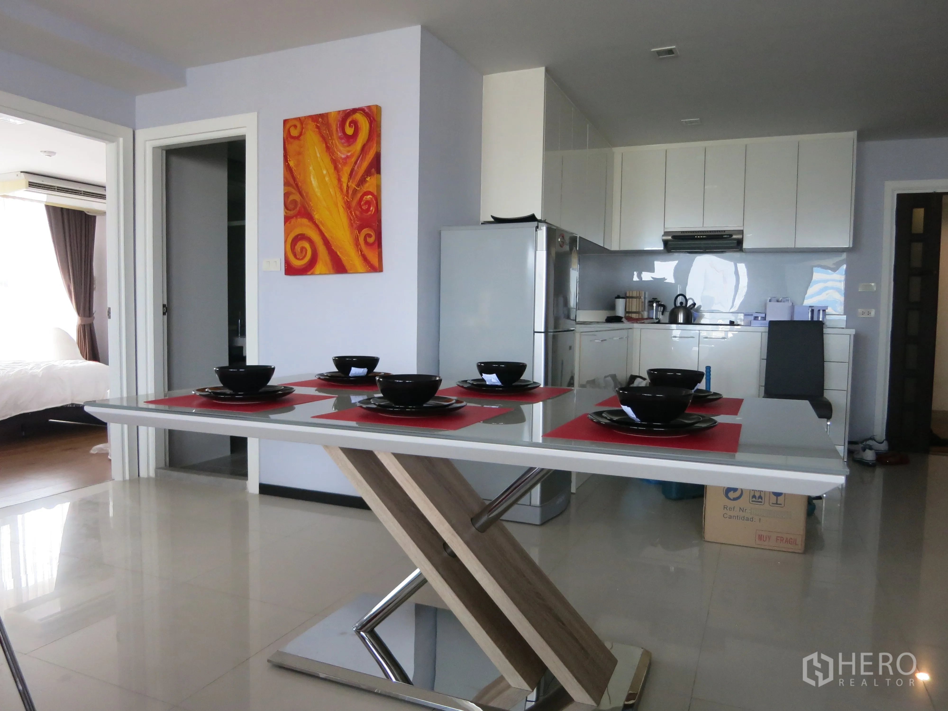 公寓 出租或出售在Watthana, Bangkok - 用餐区与开放式厨房，现代餐桌与墙面装饰画。
