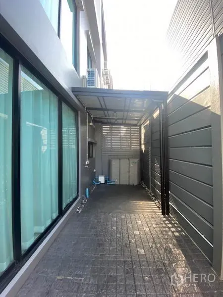 Townhouse for rent in Saphan Sung, Bangkok - Covered side yard and service area with privacy fencing and sliding glass doors.