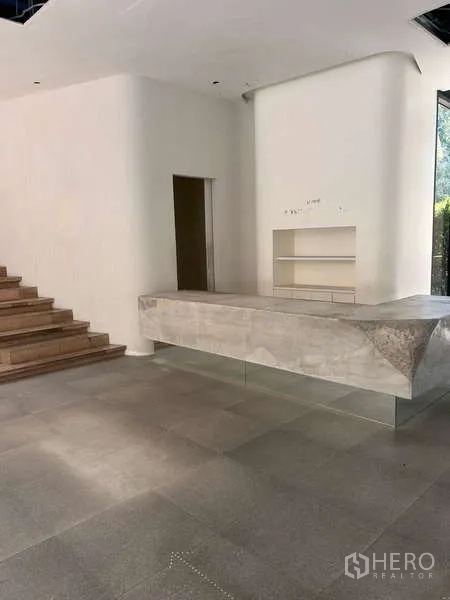 Standalone for rent in Khlong Toei, Bangkok - Lobby space with a concrete counter, broad tiled floor and staircase connection.