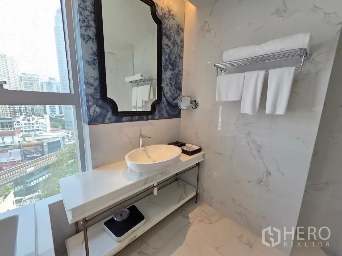 Condominium for rent - Built-in stacked washer and dryer beside the kitchen sink and marble backsplash.