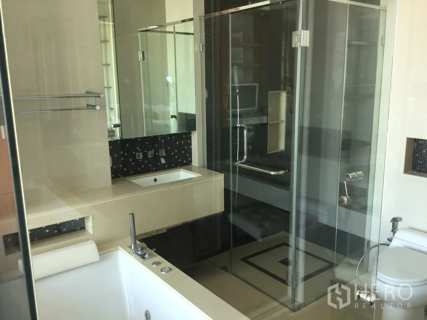 Condominium for rent in Khlong Toei, Bangkok - Modern bathroom with glass shower, soaking tub, vanity counter and toilet.