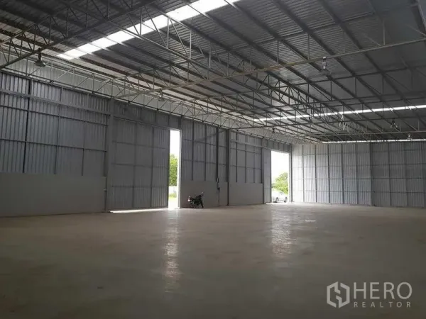 Warehouse for rent in Lat Krabang, Bangkok - Large sliding doors opening to a loading area with a wide clear span and polished concrete floor.
