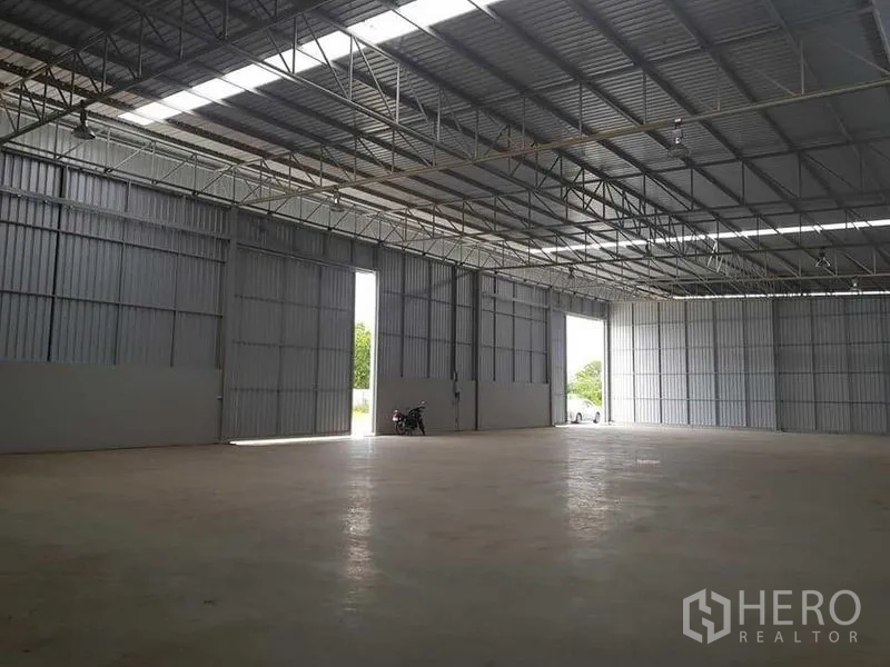 Warehouse for rent in Lat Krabang, Bangkok - Large sliding doors opening to a loading area with a wide clear span and polished concrete floor.