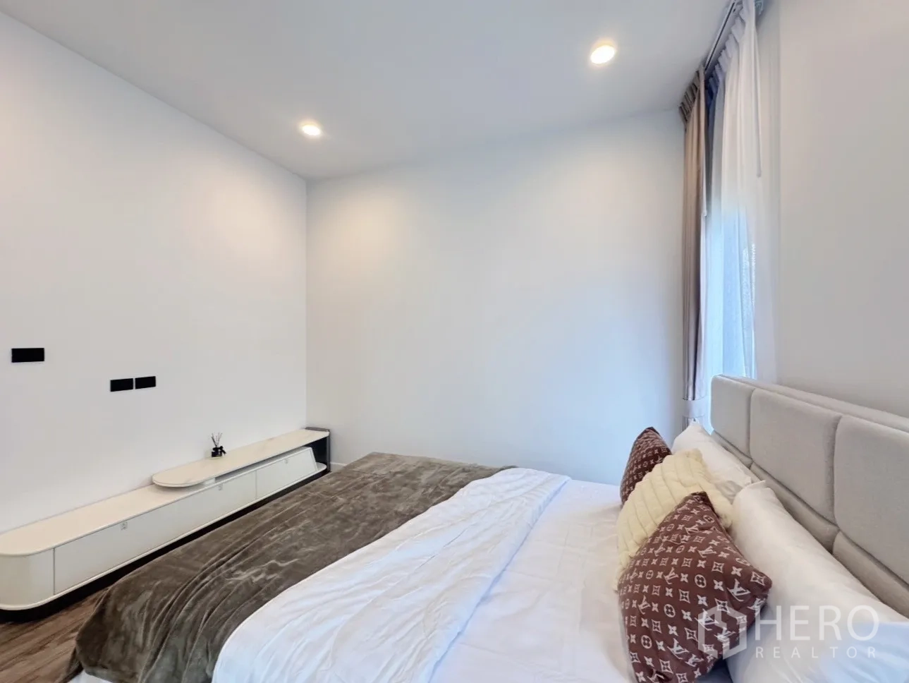 Detached House for rent or sale in Bang Kapi, Bangkok - Guest bedroom with neutral bedding and minimalist built-in cabinet.