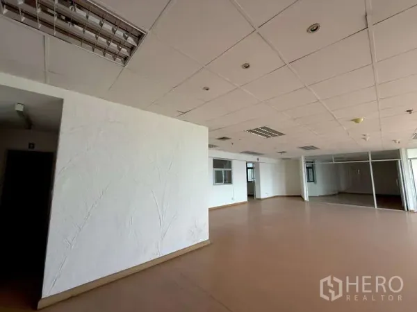 Office Space for rent in Chatuchak, Bangkok - Unfurnished office corner featuring a textured white accent wall and a glass-partitioned meeting room.