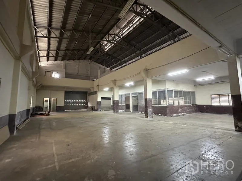 Factory for rent in Bang Bua Thong, Nonthaburi - High-clearance warehouse with steel-truss roof and loading door.
