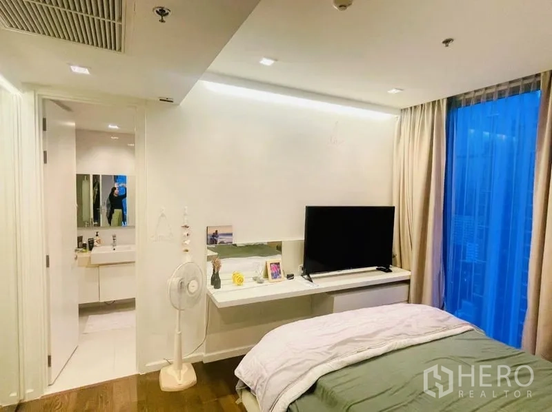 Condominium for rent or sale in Sathon, Bangkok - Bedroom with TV console and access to an ensuite bathroom.