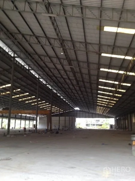 货栈 出租在Mueang Chon Buri, Chon Buri - 仓库内部，高钢结构桁架屋顶与采光天窗，开阔的混凝土地面。