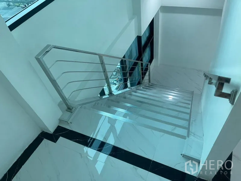 带办公室的家 出租或出售在Wang Thonglang, Bangkok - 采光良好的楼梯间，金属栏杆与黑边地砖