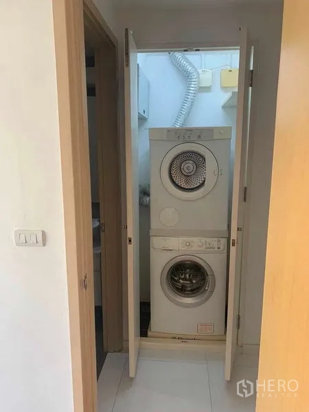 Condominium for rent or sale in Khlong Toei, Bangkok - Stacked washer and dryer in a concealed closet.