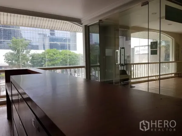 Retail Space for rent in Khlong Toei, Bangkok - Open retail area with built-in wooden counter, glass meeting room and full-height windows to the city.