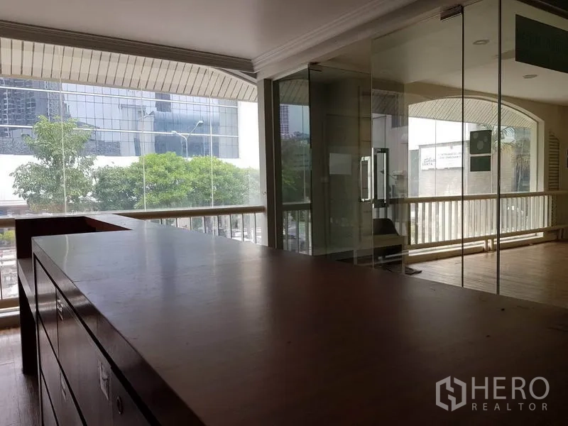 Retail Space for rent in Khlong Toei, Bangkok - Open retail area with built-in wooden counter, glass meeting room and full-height windows to the city.