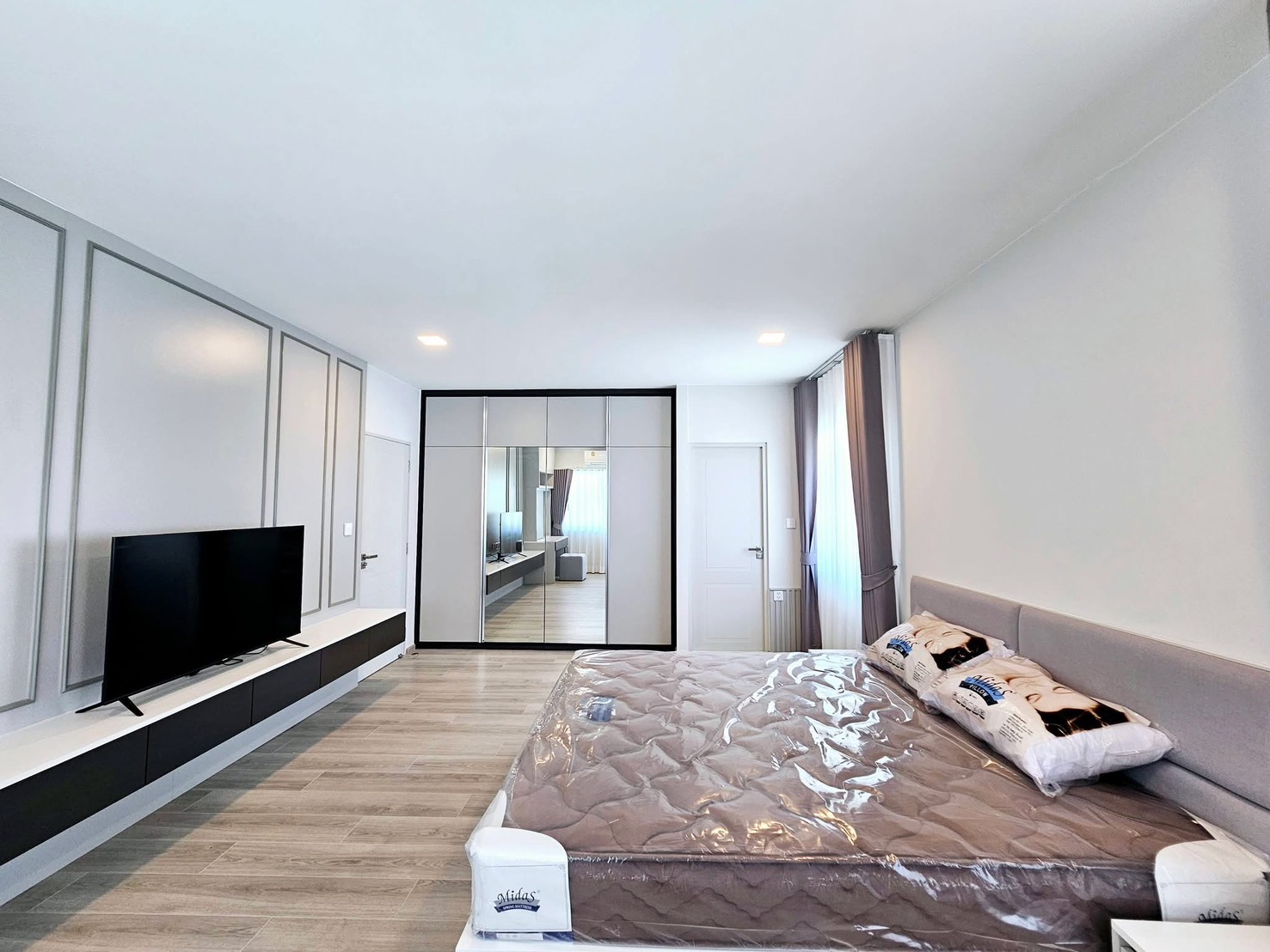 บ้าน ให้เช่าในBang Phli, Samut Prakan - ห้องนอนใหญ่ ตู้เสื้อผ้าบานกระจก ผนังคอนโซลทีวี และพื้นไม้