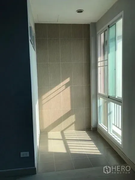 Detached House for rent - Compact nook with beige feature wall and sliding windows opening toward a balcony.