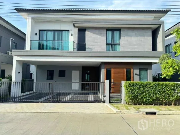 Detached House for rent or sale in Bang Phli, Samut Prakan - Contemporary two-storey detached house facade with balcony, double carport and gated front yard.