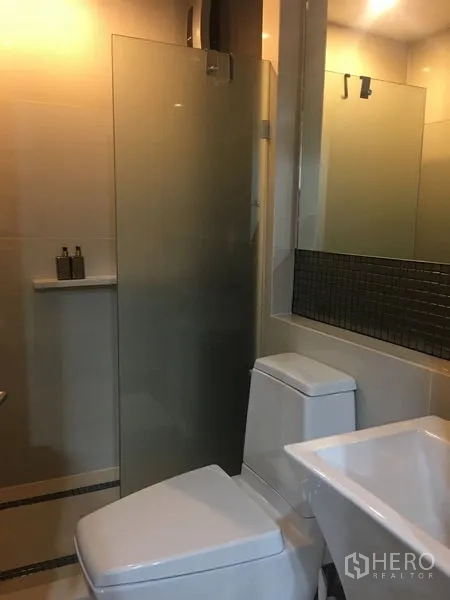 公寓 出租在Khlong Toei, Bangkok - 现代卫浴，玻璃淋浴间、大镜面、台盆与马桶。
