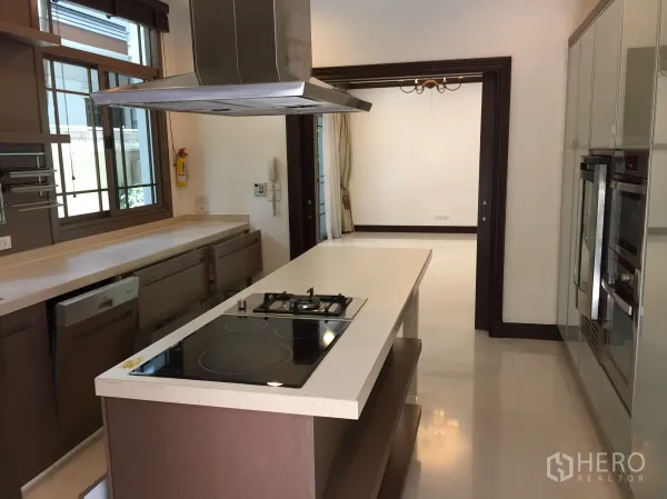 Detached House for rent in Yan Nawa, Bangkok - Modern island kitchen with cooktop, range hood and built-in ovens.