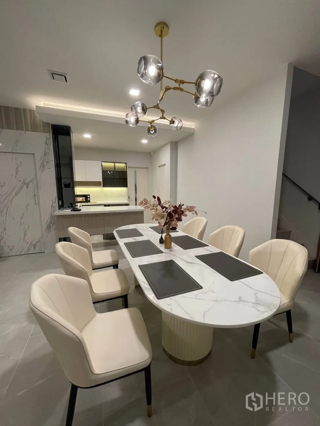 独栋房屋 for rent in Prawet, Bangkok - 六人位大理石餐桌，金色枝形吊灯，下方连通厨房。