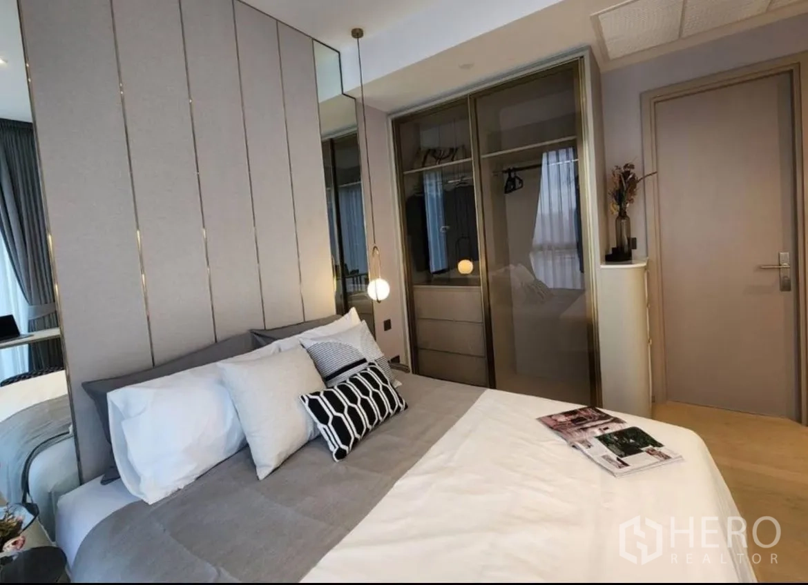 Condominium for rent in Din Daeng, Bangkok - Bedroom with sliding glass wardrobe doors and neutral contemporary decor.