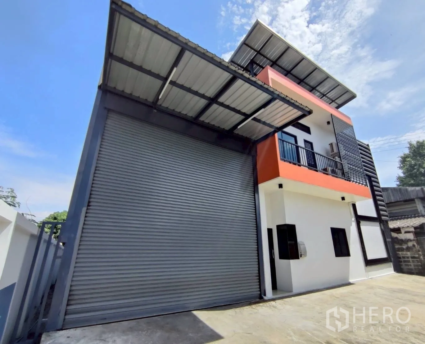 Warehouse for rent in Lam Luk Ka, Pathum Thani - Exterior view showing an oversize roller shutter and covered loading bay.