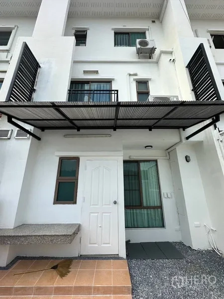 Townhouse for rent or sale in Phra Khanong, Bangkok - Rear exterior of the townhouse with metal awning over the patio and windows.