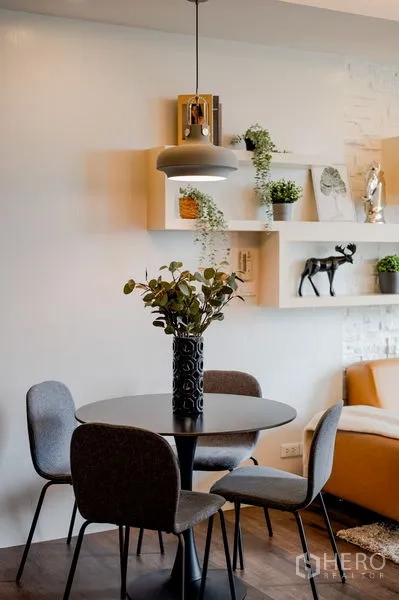 Condominium for sale in Khlong Toei, Bangkok - Close-up of a round dining table for four with pendant light and decorative shelves.