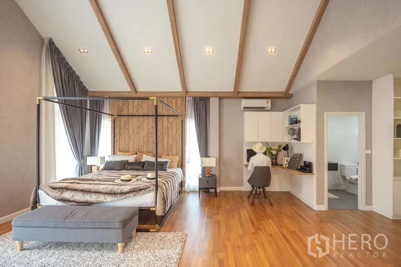 Detached House for sale in Lam Luk Ka, Pathum Thani - Spacious master bedroom with vaulted ceiling, canopy bed and work corner.