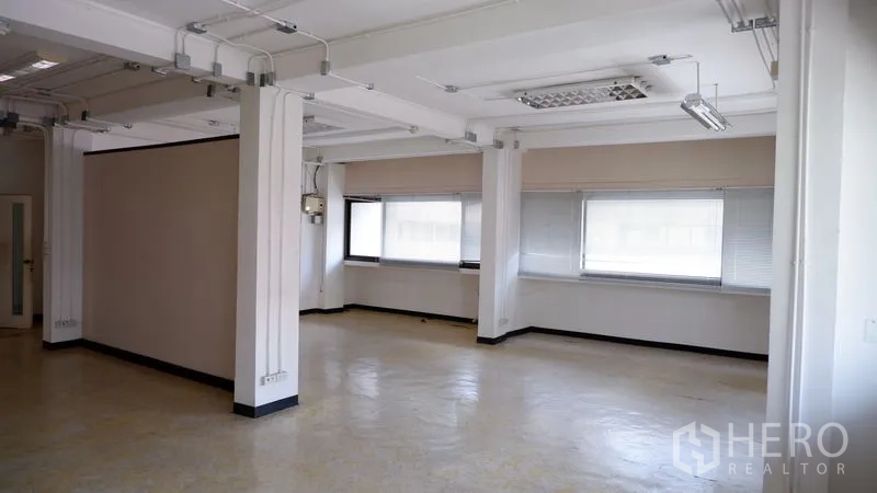 办公空间 出租在Watthana, Bangkok - 大面积弹性工作区，多窗配百叶，天花外露电线管路。