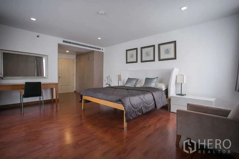 Condominium for rent or sale in Watthana, Bangkok - Master bedroom with king bed, study desk and wardrobe cabinetry.