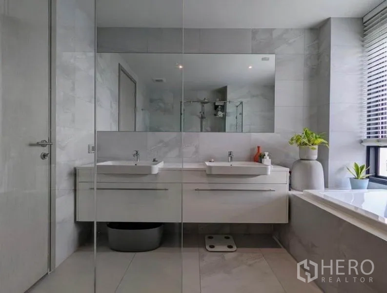 公寓 出租在Watthana, Bangkok - 浴室配双台盆与大镜面，设有采光窗。