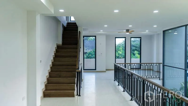 独立式住宅 出租或出售在Suan Luang, Bangkok - 宽阔楼梯平台，黑色栏杆与大窗