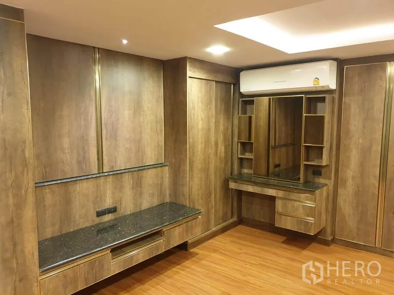 Condominium for rent in Khlong Toei, Bangkok - Custom wood-built bedroom with built-in wardrobes, vanity and air conditioner in a Khlong Toei condo.