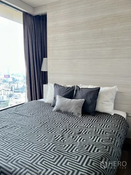 公寓 出租在Khlong Toei, Bangkok - 主卧带大窗与浅色墙面，享城市景观。