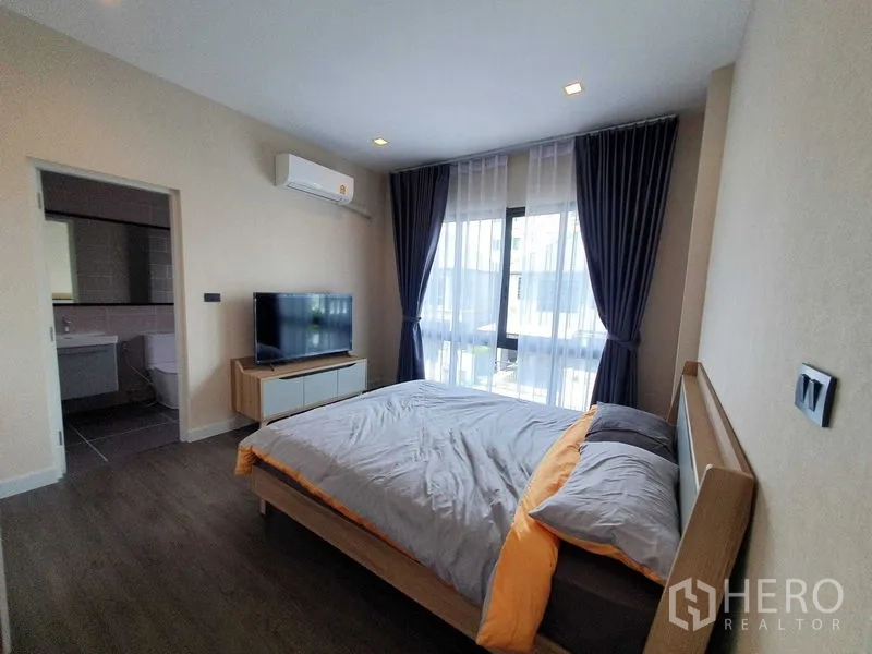 Detached House for rent in Khlong Luang, Pathum Thani - Bright bedroom with double bed, TV console, air conditioner and an ensuite bathroom.